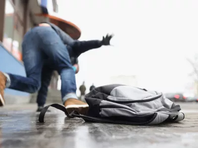 Close-up of person get injury after falling on slippery ground in winter season. Personal backpack lay on asphalt ice. Accident, trauma, clumsy concept / Foto: Ivan-balvan Getty Images