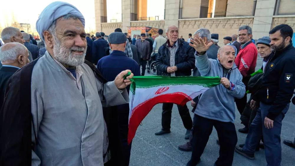 A worshipper chants slogan as he holds an Iranian flag with a cleric after the conclusion of the Friday prayers ceremony at the Imam Khomeini Grand Mosque in Tehran, Iran, Friday, Feb. 27, 2026. (AP Photo/Vahid Salemi) / Foto: Vahid Salemi
