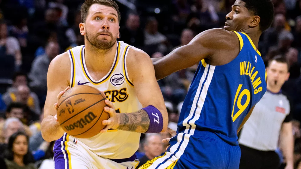 Los Angeles Lakers guard Luka Doncic (77) drives past Golden State Warriors guard Nate Williams (19) during the third quarter of their NBA basketball game in San Francisco Saturday, Feb. 28, 2026. (Stephen Lam/San Francisco Chronicle via AP)