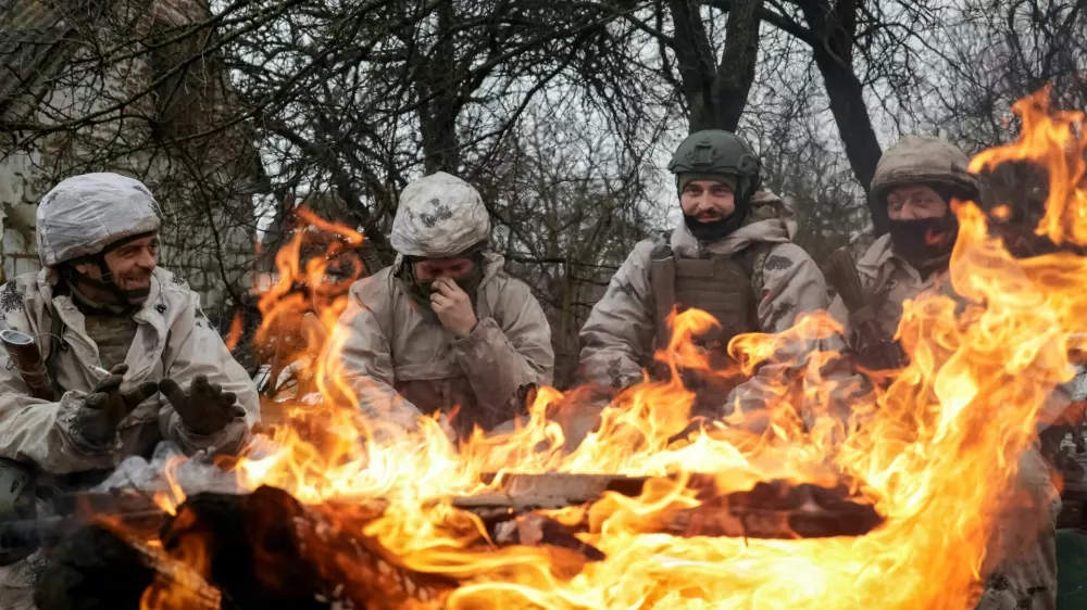 Recruits of the 28th Separate Mechanized Brigade of the Armed Forces of Ukraine warm themselves by the fire during a military exercise before combat missions, amid Russia's attack on Ukraine, in Kharkiv region, Ukraine February 26, 2026. REUTERS/Sofiia Gatilova