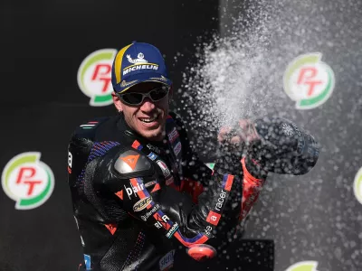 MotoGP - Thailand Grand Prix - Chang International Circuit, Buriram, Thailand - March 1, 2026 Aprilia Racing's Marco Bezzecchi celebrates winning the MotoGP race on the podium with the trophy REUTERS/Chalinee Thirasupa