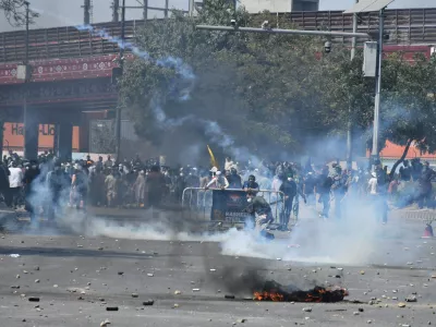 Shiite Muslims hurl back a tear gas shell fired by police to disperse them during a protest to condemn the killing of Iranian Supreme Leader Ayatollah Ali Khamenei, in Karachi, Pakistan, Sunday, March 1, 2026. (AP Photo/Ali Raza)