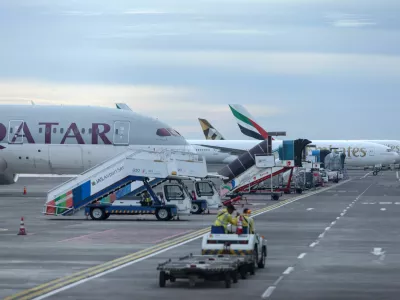 Qatar Airways and Emirates Airways plane is parked at I Gusti Ngurah Rai International Airport as some flights to Dubai and Doha cancelled following strikes on Iran launched by the United States and Israel, in Kuta, Bali, Indonesia, March 1, 2026. REUTERS/Johannes Christo