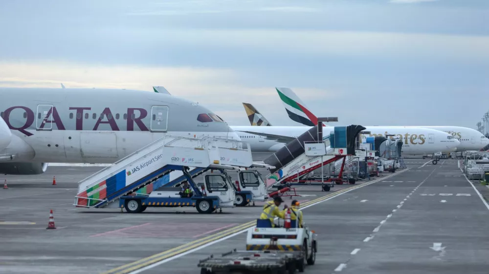 Qatar Airways and Emirates Airways plane is parked at I Gusti Ngurah Rai International Airport as some flights to Dubai and Doha cancelled following strikes on Iran launched by the United States and Israel, in Kuta, Bali, Indonesia, March 1, 2026. REUTERS/Johannes Christo