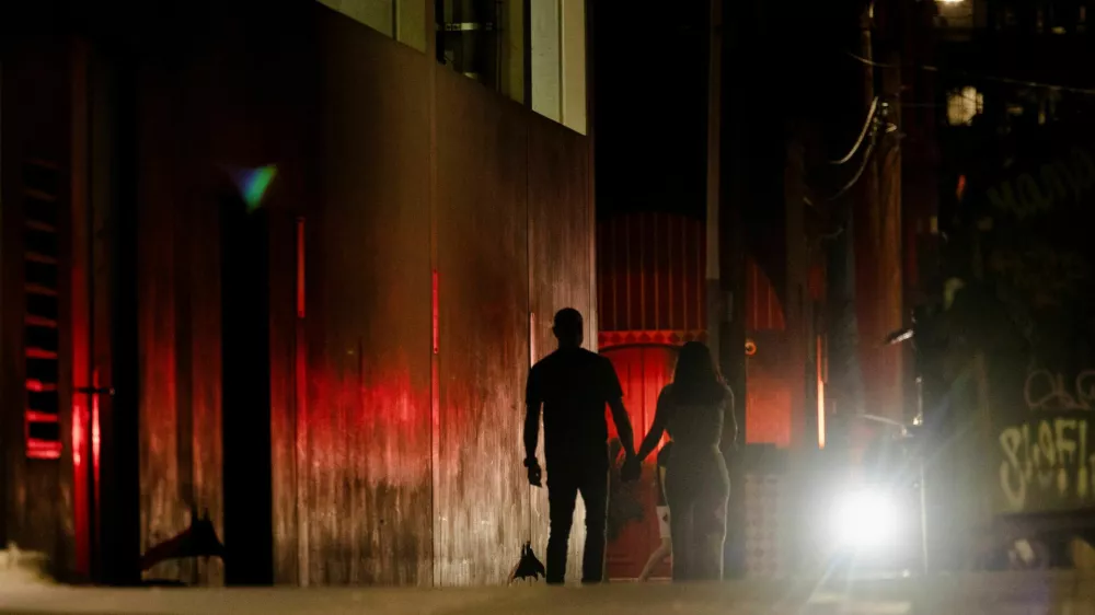 A couple makes their way around barricaded streets off Sixth Street after a deadly mass shooting outside Buford's, a popular roadhouse-style bar in Austin, Texas, U.S. March 1, 2026. REUTERS/Nuri Vallbona