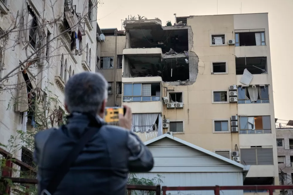 A man takes pictures of the damage in an apartment building after it was hit by an Israeli airstrike in Dahiyeh, Beirut's southern suburb, Lebanon, Monday, March 2, 2026. (AP Photo/Hussein Malla)