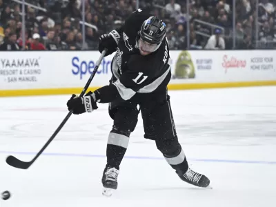 Feb 28, 2026; Los Angeles, California, USA; Los Angeles Kings center Anze Kopitar (11) shoots the puck during the second period against the Calgary Flames at Crypto.com Arena. Mandatory Credit: Griffin Hooper-Imagn Images