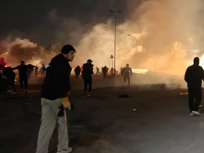 Security forces fire tear gas to disperse a protest against U.S. and Israeli attacks on Iran, at a bridge leading to the fortified Green Zone where the U.S. Embassy is located, in Baghdad, Iraq, Monday, March 2, 2026. (AP Photo/Hadi Mizban)