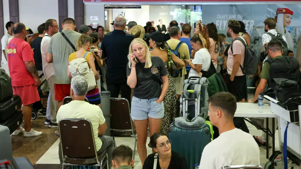 Stranded passengers wait near Emirates Airways customer service office at I Gusti Ngurah Rai International Airport after flights to Doha, Dubai, and Abu Dhabi were cancelled following strikes on Iran launched by the United States and Israel, in Kuta, Bali, Indonesia, March 1, 2026. REUTERS/Johannes Christo