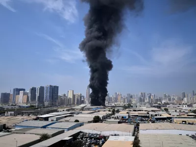A black plume of smoke rises from a warehouse at the industrial area of Sharjah City in the United Arab Emirates following reports of Iranian strikes in Dubai, United Arab Emirates, Sunday, March 1, 2026. (AP Photo/Altaf Qadri)