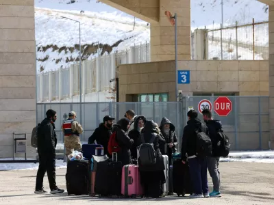 Iranians stand at the Kapikoy Border Gate as they wait to cross from Turkey into Iran, in the eastern province of Van, Turkey, March 4, 2026. REUTERS/Dilara Senkaya