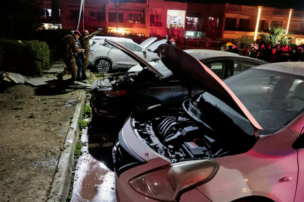 People gather near debris from a drone that fell onto a building near Erbil airport, amid the U.S.-Israeli conflict with Iran, in the Ankawa district of Erbil, Iraq, March 4, 2026. REUTERS/Khalid al Mousily