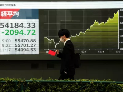 A man walks past a screen displaying Japan's Nikkei share average and graph showing recent movements, outside a brokerage in Tokyo, Japan March 4, 2026. REUTERS/Issei Kato