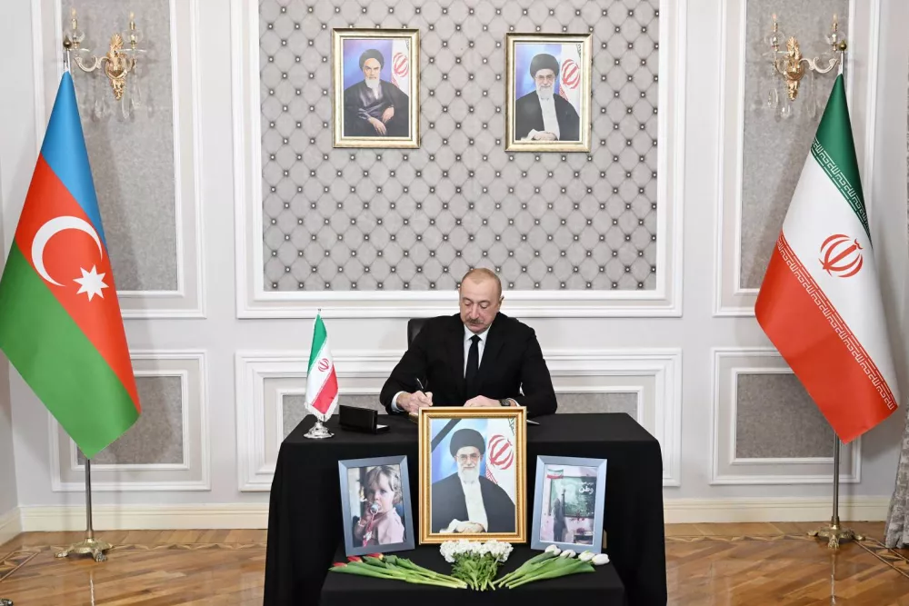 In this photo provided by Azerbaijan's Presidential Press Service, Azebaijan's President Ilham Aliyev writes a message in a condolence book for the late Iranian Supreme Leader Ayatollah Ali Khamenei at the Iranian Embassy in Baku, Azerbaijan, Wednesday, March 4, 2026. (Azerbaijan's Presidential Press Service via AP)