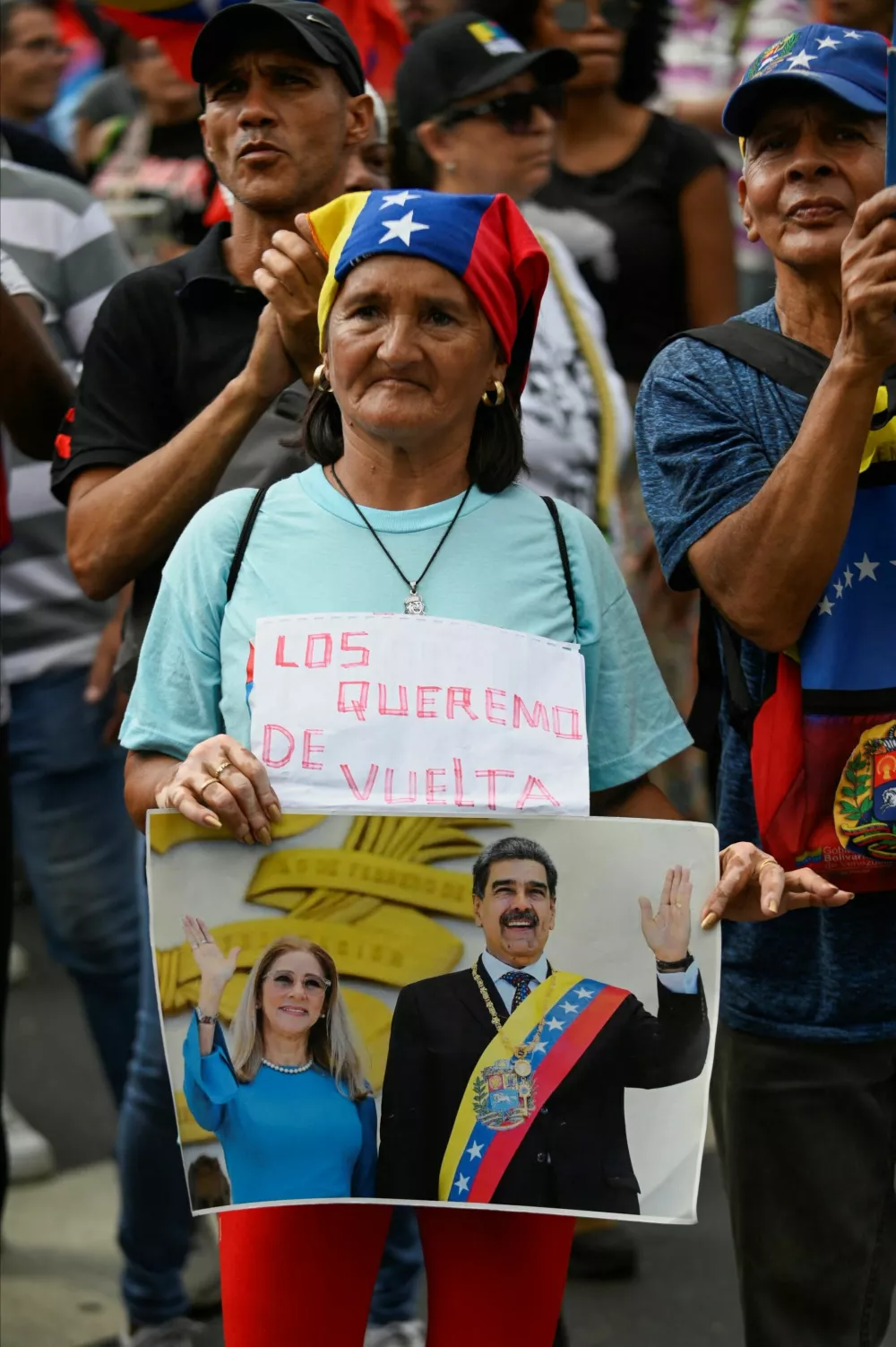 A woman holds a sign reading "We want them back" next to a photo of ousted President Nicolas Maduro and his wife, Cilia Flores, during a demonstration demanding their return, two months after their capture by the United States, in Caracas, Venezuela, March 3, 2026. REUTERS/Maxwell Briceno