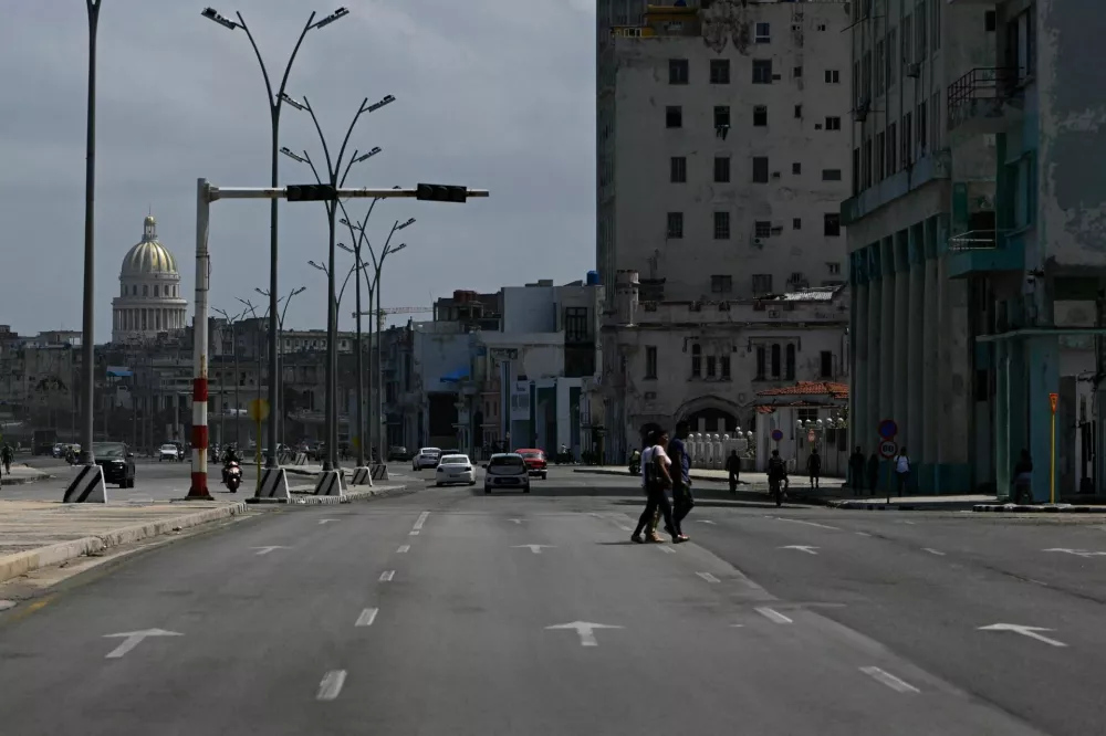 People cross an avenue as traffic lights are off during a mass blackout across most of the country, in Havana, Cuba March 4, 2026. REUTERS/Norlys Perez