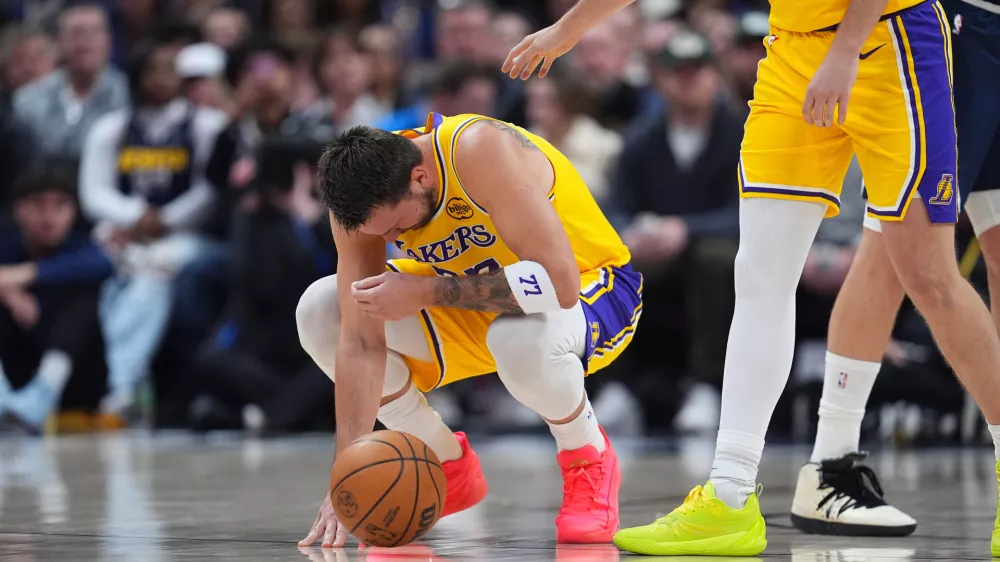 Los Angeles Lakers guard Luka Dončić reacts after getting hit in the face by the ball in the first half of an NBA basketball game against the Denver Nuggets Thursday, March 5, 2026, in Denver. (AP Photo/David Zalubowski)