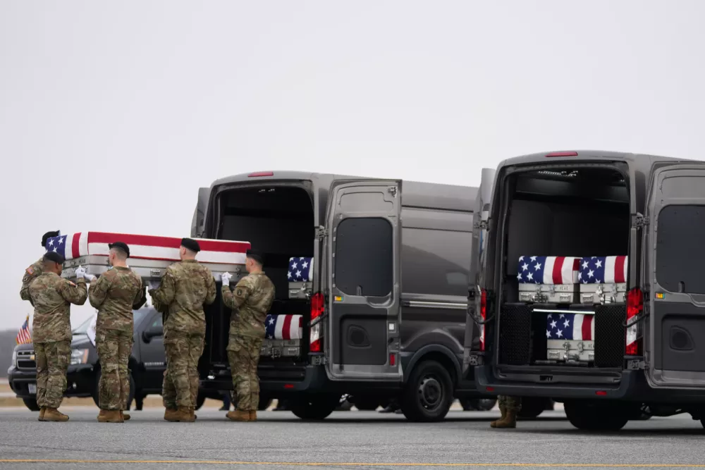 An Army carry team moves a flag-draped transfer case with the remains of Sgt. Declan Coady, 20, of West Des Moines, Iowa, who was killed in a drone strike at a command center in Kuwait after the U.S. and Israel launched its military campaign against Iran, past President Donald Trump and first lady Melania Trump during a casualty return, Saturday, March 7, 2026, at Dover Air Force Base, Del. (AP Photo/Mark Schiefelbein)