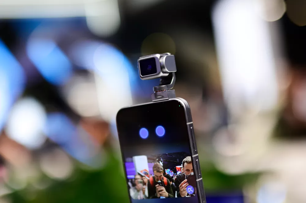 The 5 Honor Robot Phone is showcased at MWC 2026, featuring its signature motorized robotic camera arm. The device, which Honor calls a ''new species'' of smartphone, uses a self-developed micro-motor, 70% smaller than standard industry solutions, to deploy a 200MP camera on a three-axis gimbal. During the live demonstration, the robotic arm tracks subjects autonomously and responds to voice commands with human-like ''nods'' and ''shakes.'' This integration of embodied AI and mechanical motion allows the phone to perform cinematic pans, keep users perfectly centered during video calls, and even ''dance'' to music, marking a major leap in mobile videography and interactive hardware during the Mobile World Congress (MWC) in Barcelona, Spain, on March 5, 2026. (Photo by Joan Cros/NurPhoto)NO USE FRANCE