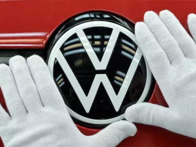 FILE PHOTO: A technician cleans the VW logo during the final inspection of German carmaker Volkswagen's electric ID. 3 car, during a media tour, in Dresden, Germany, May 14, 2025. REUTERS/Matthias Rietschel/File Photo
