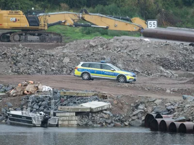 05 August 2025, Saxony, Dresden: A police vehicle stands on the construction site at the demolished Carola Bridge on the Neustadt side of the Elbe. Another bomb from the Second World War has been found during clearance work on the former Elbe crossing. Photo: Sebastian Kahnert/dpa