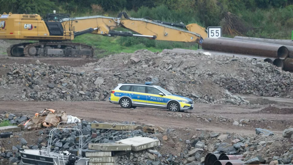 05 August 2025, Saxony, Dresden: A police vehicle stands on the construction site at the demolished Carola Bridge on the Neustadt side of the Elbe. Another bomb from the Second World War has been found during clearance work on the former Elbe crossing. Photo: Sebastian Kahnert/dpa