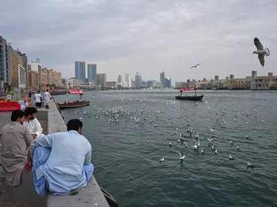 Afghan men watch as seagulls fly over Dubai Creek in Dubai, United Arab Emirates, Tuesday, March 10, 2026. (AP Photo/ Fatima Shbair)
