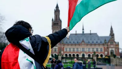 FILE PHOTO: A man waves a Palestinian flag as people protest on the day of a public hearing held by The International Court of Justice (ICJ) to allow parties to give their views on the legal consequences of Israel's occupation of Palestinian territories before eventually issuing a non-binding legal opinion, in The Hague, Netherlands, February 21, 2024. REUTERS/Piroschka van de Wouw/File Photo