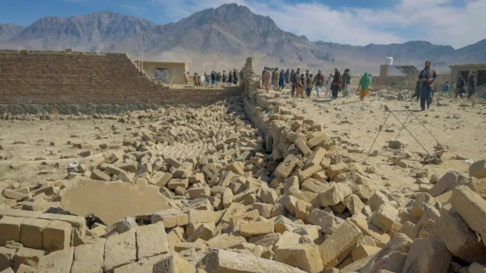 People stand near a house damaged in what the Taliban said was a Pakistani air strike on the outskirts of Kabul, Afghanistan, March 13, 2026. Picture taken with a mobile phone. REUTERS/Sayed Hassib