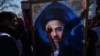 People hold a portrait of new Iranian Supreme Leader Ayatollah Mojtaba Khamenei as they march during a protest against Israel and the U.S., in Istanbul, Friday, March 13, 2026. (AP Photo/Francisco Seco)