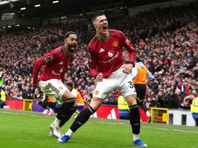 Manchester United's Benjamin Sesko, right, celebrates scoring their side's third goal of the game with team-mate Matheus Cunha during the Premier League match between Manchester United and Aston Villa, in Manchester, England, Sunday March 15, 2026. (Martin Rickett/PA via AP)
