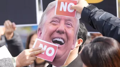 Protesters attach stickers on an image of U.S. President Donald Trump to protest against Trump's demands to multiple countries to send warships to keep the Strait of Hormuz open, near the U.S. Embassy in Seoul, South Korea, Monday, March 16, 2026. (AP Photo/Lee Jin-man)