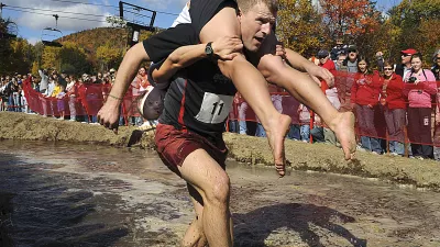 Reeder Famnestock with Sarah Silverberg of Dover, N.H. exit the bog on the race course in the annual North American Wife-Carrying Competition held at the Sunday River Ski Resort in Newry, Maine, on Saturday, Oct. 11, 2008. (AP Photo/The Sun-Journal, Jose Leiva)