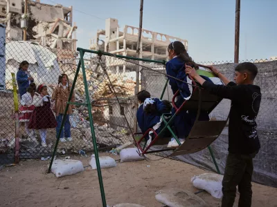 Displaced Palestinian children play on a swing at a tent camp as they mark the Muslim holiday of Eid al-Fitr in Gaza City, Friday, March 20, 2026. (AP Photo/Abdel Kareem Hana)