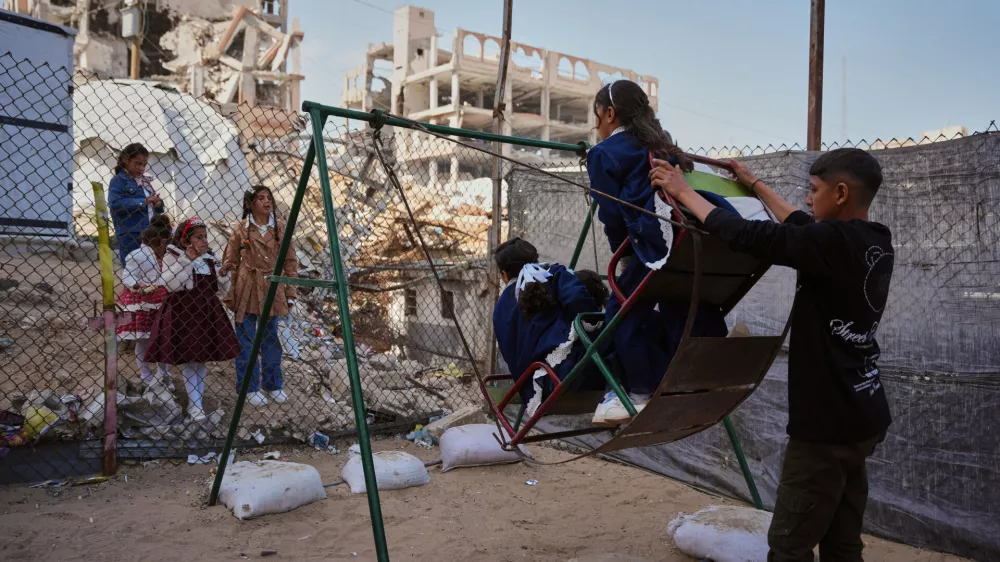 Displaced Palestinian children play on a swing at a tent camp as they mark the Muslim holiday of Eid al-Fitr in Gaza City, Friday, March 20, 2026. (AP Photo/Abdel Kareem Hana)
