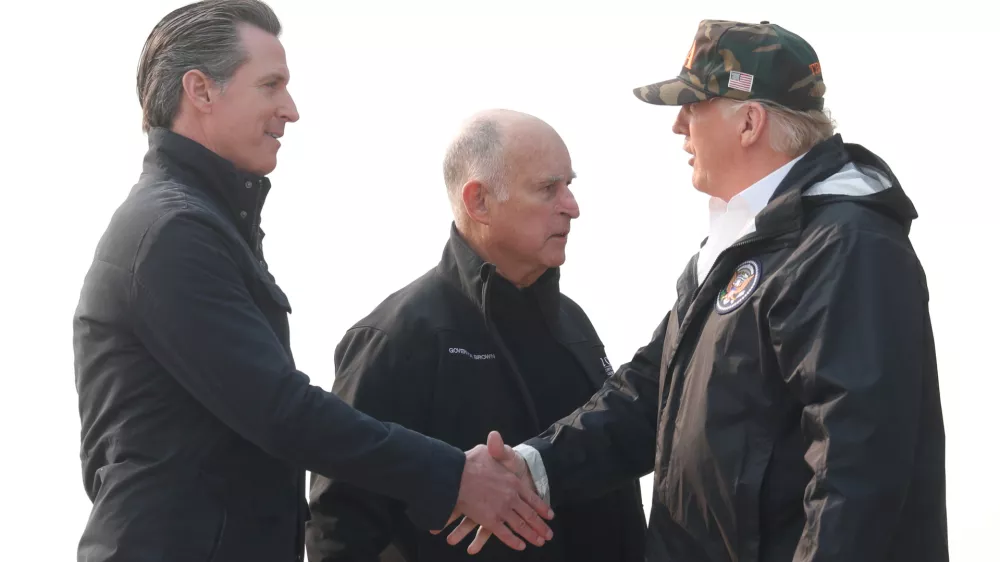 U.S. President Donald Trump shakes hands with Governor-elect Gavin Newsom (L) after greeting Governor Jerry Brown (C) upon arriving at Beale Air Force Base, California, U.S., November 17, 2018. REUTERS/Leah Millis