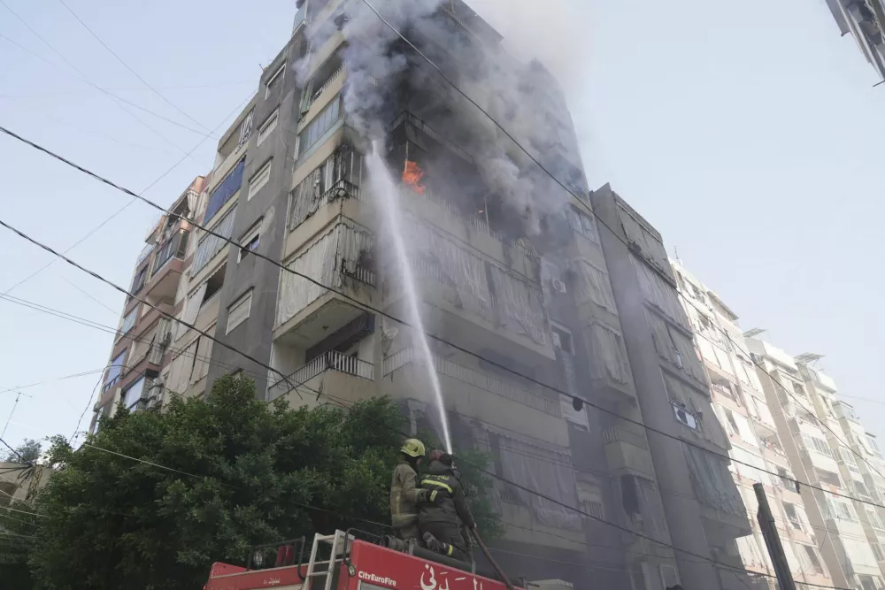Members of the Lebanese Civil Defence work to extinguish a fire in a building after an Israeli strike on Beirut, following an escalation between Hezbollah and Israel amid the U.S.-Israeli conflict with Iran, Lebanon, March 18, 2026. REUTERS/Stringer