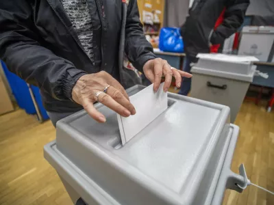 A woman casts her vote at a local polling station during the general election and national referendum on the child protection law in Budapest, Hungary, Sunday, April 3, 2022. (Gyorgy Varga/MTI via AP)