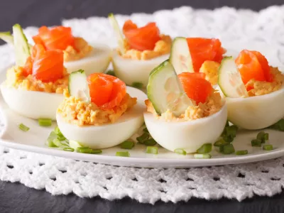 Eggs stuffed with salmon close-up on a plate on the table. horizontal / Foto: Alleko