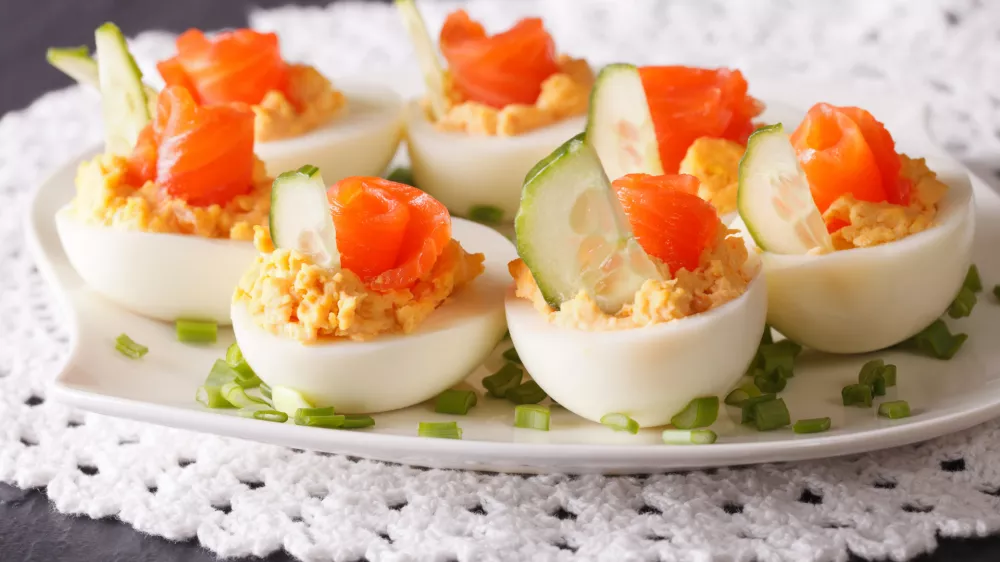 Eggs stuffed with salmon close-up on a plate on the table. horizontal / Foto: Alleko