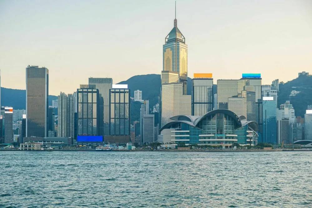 Wide panoramic view of Hong Kong skyline along Victoria Harbour with modern skyscrapers and Hong Kong Convention and Exhibition Centre at sunset, China. Global city, financial power, international business, modern Asia. / Foto: Samael334