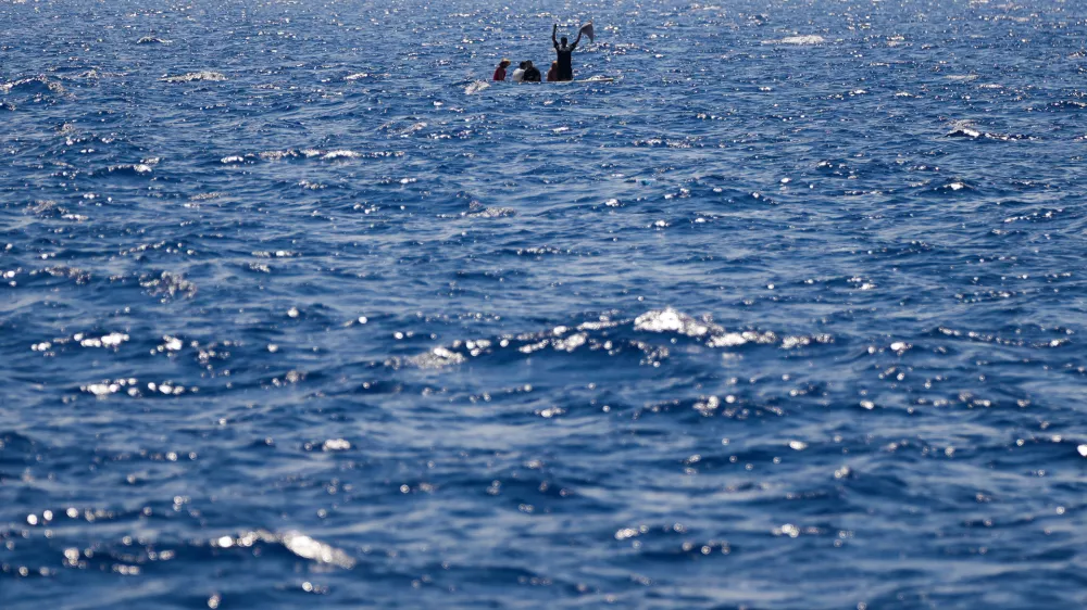 FILE-- Migrants from Syria and Libya in a wooden boat call for help as they are assisted by Spanish NGO Open Arms during a rescue operation inside Malta's SAR zone south of the Italian island of Lampedusa in the Mediterranean Sea, Wednesday, Aug. 10, 2022. (AP Photo/Francisco Seco)