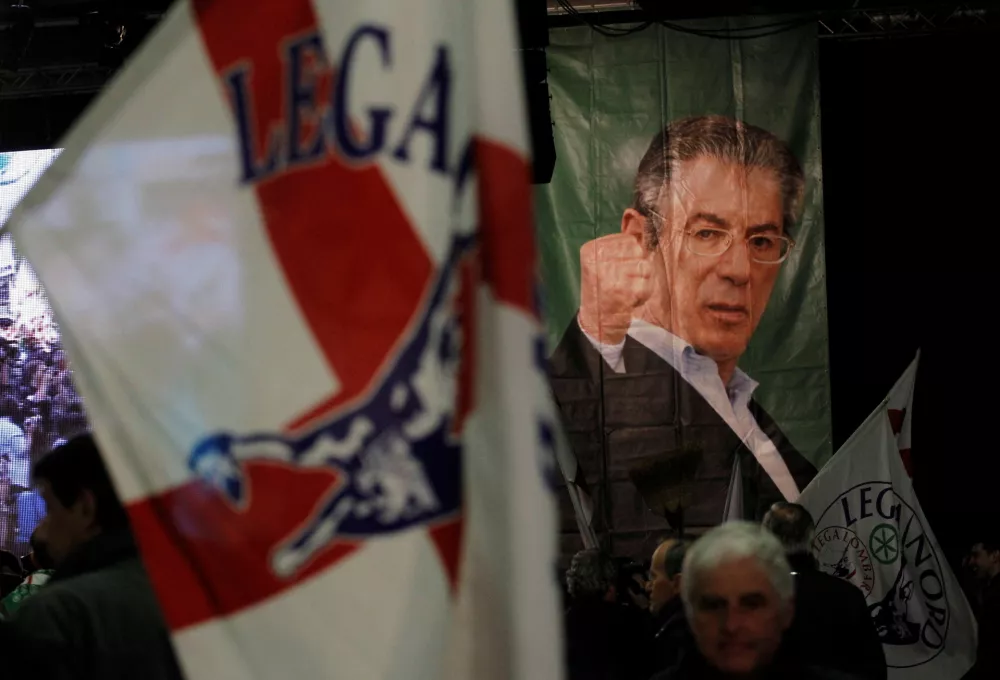 FILE PHOTO: A picture of Italy's Northern League former leader Umberto Bossi is seen on a poster during the Northern League rally in Bergamo April 10, 2012. Umberto Bossi, the firebrand leader of Italy's opposition Northern League party, resigned on Thursday after allegations that taxpayers' money was used to pay for renovations at his villa and holidays for his children. REUTERS/Alessandro Garofalo/File Photo