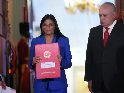 Acting President Delcy Rodriguez holds up an amnesty bill approved by the National Assembly alongside Interior Minister Diosdado Cabello at Miraflores Palace in Caracas, Venezuela, Thursday, Feb. 19, 2026. (AP Photo/Ariana Cubillos)