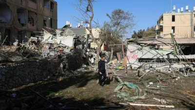A man walks near debris from damage following a night of Iranian missile strikes which injured dozens of Israelis, amid the U.S.-Israel conflict with Iran, in Dimona, southern Israel, March 22, 2026. REUTERS/Ronen Zvulun
