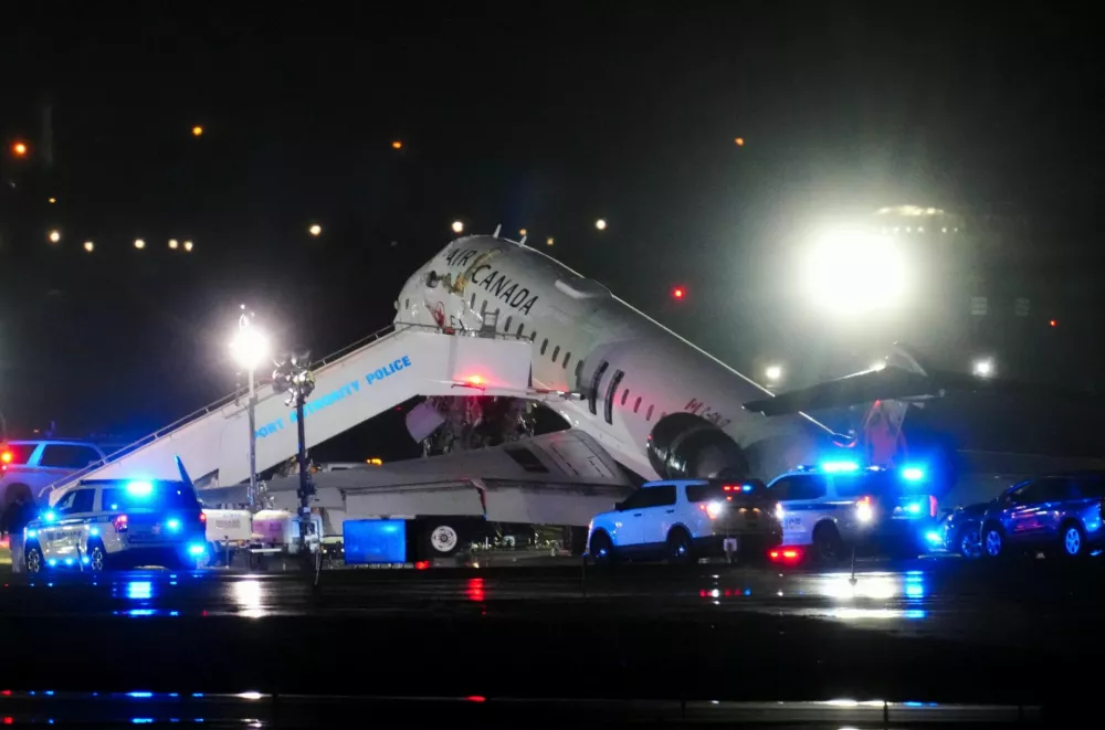 Emergency vehicles are parked near an Air Canada Express jet that had collided with a fire truck at LaGuardia Airport in Queens, New York, U.S. March 23, 2026. REUTERS/Adam Gray