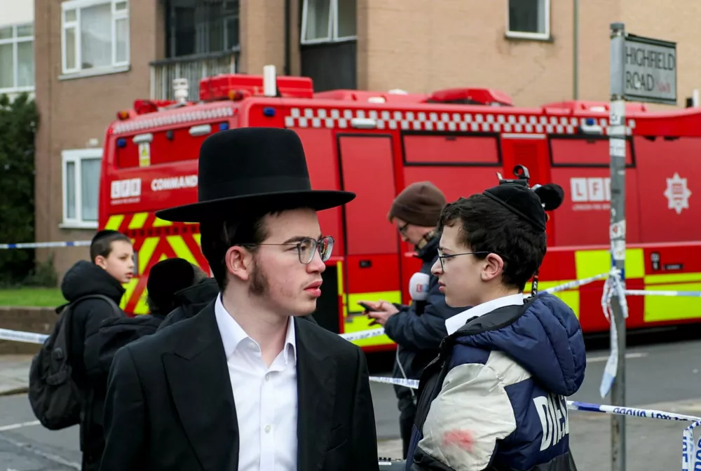 Jewish people react next to a police cordon line near the scene, after four ambulances belonging to Hatzola, a Jewish community organisation, were set on fire in an incident that the police say is being treated as an antisemitic hate crime, in northwest London, Britain, March 23, 2026. REUTERS/Isabel Infantes