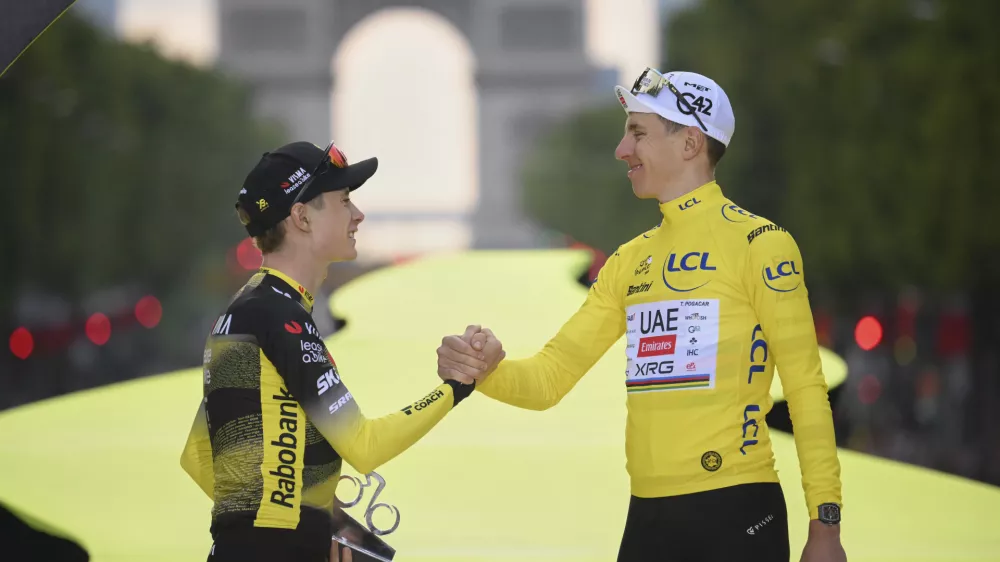 Denmark's Jonas Vingegaard, second placed, left, greets Slovenia's Tadej Pogacar, the Tour de France winner, during the presentation ceremony for the Tour de France on the Champs-Elysees in Paris, France, Sunday, July 27, 2025. (Bernard Papon, Pool Photo via AP)