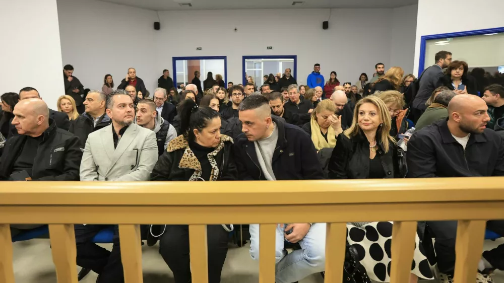Relatives of victims of the 2023 Tempi train crash, that killed 57 people, wait for the start of the trial in Larissa, Greece, March 23, 2026. REUTERS/Kostas Mantziaris