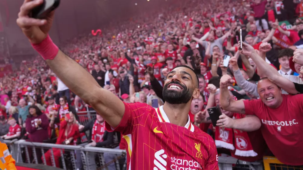 FILE - Liverpool's Mohamed Salah celebrates by taking a selfie after winning the English Premier League soccer match between Liverpool and Tottenham Hotspur and clinching the Premier League title at Anfield in Liverpool, England, April 27, 2025. (AP Photo/Jon Super, File)